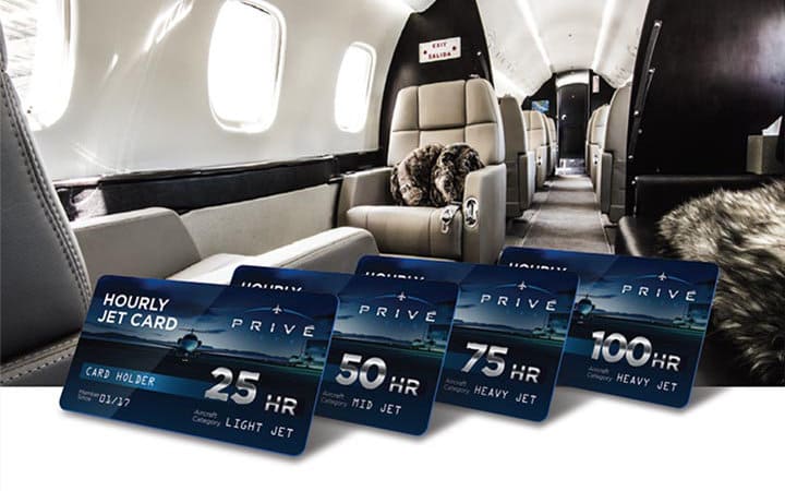 Interior of a private jet with luxurious seats and fur accents, with four hourly jet cards displayed in the foreground offering 25, 50, 75, and 100 hours of flight.